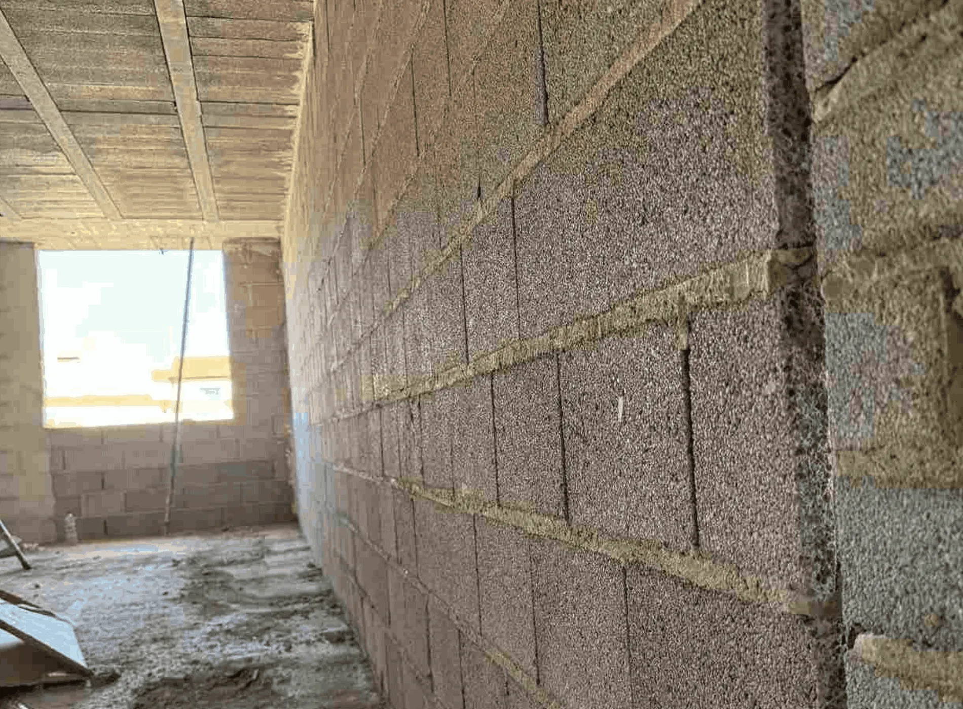Vista parcial de la fachada en obra con muro divisorio de bloque Arliblock® utilizado en la separación de viviendas, con marcas de referencia sobre el paramento.